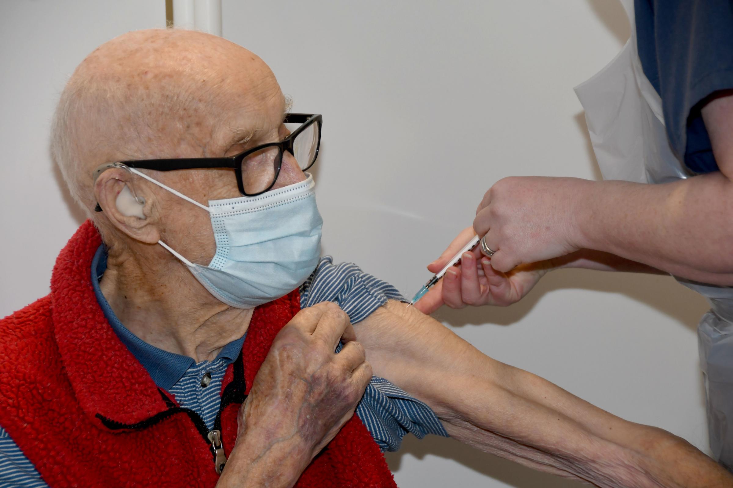 Dr Phillip Leech prepares to receive Warringtons first Covid vaccination from Dr Laura Mount