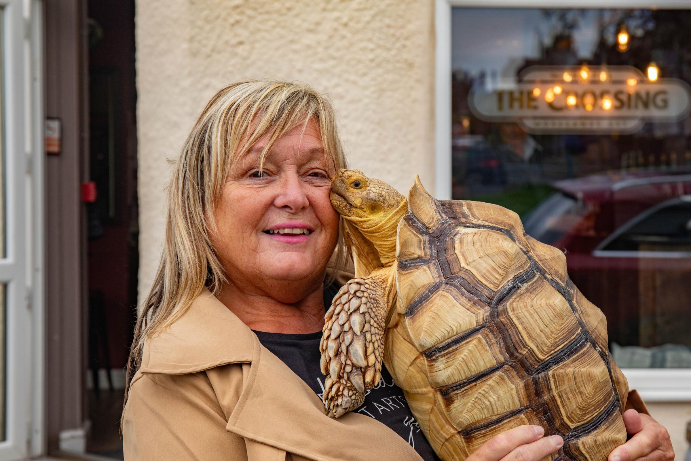 Jackie Leek takes her giant pet tortoise called Mr Miyagi on regular walks to the pub. Picture: SWNS